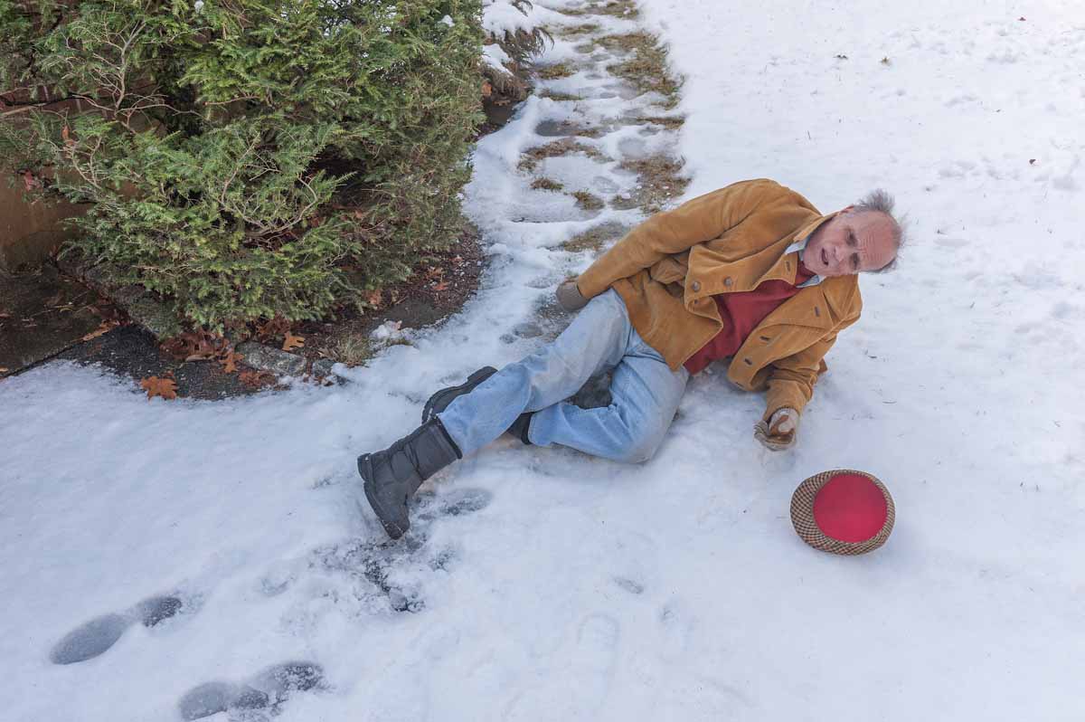 image of elderly man who has fallen on a snowy sidewalk