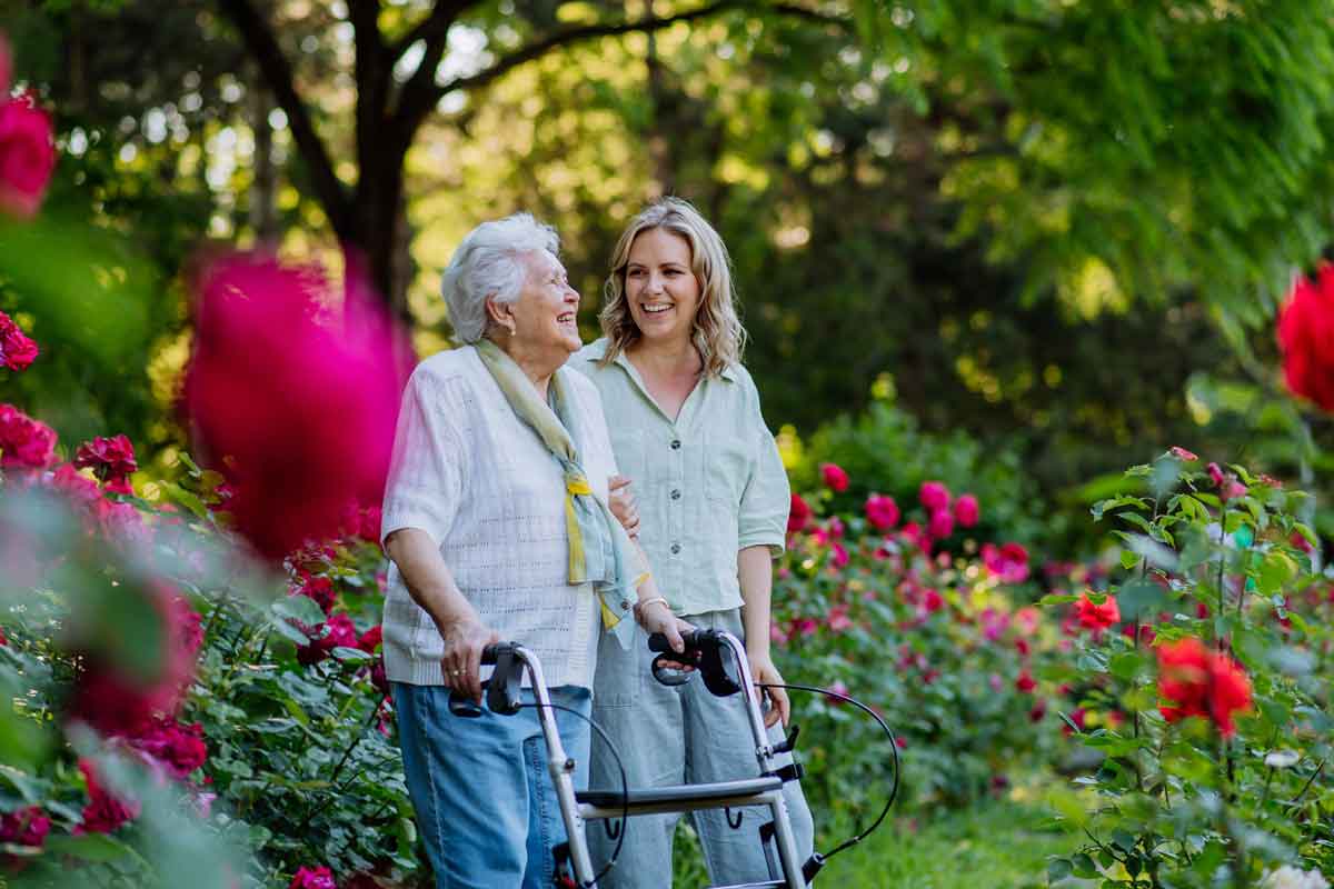 image of a Daughter walking outside with a Mother in a garden
